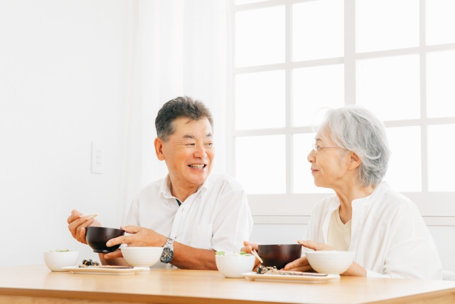 楽しく食事をする高齢夫婦